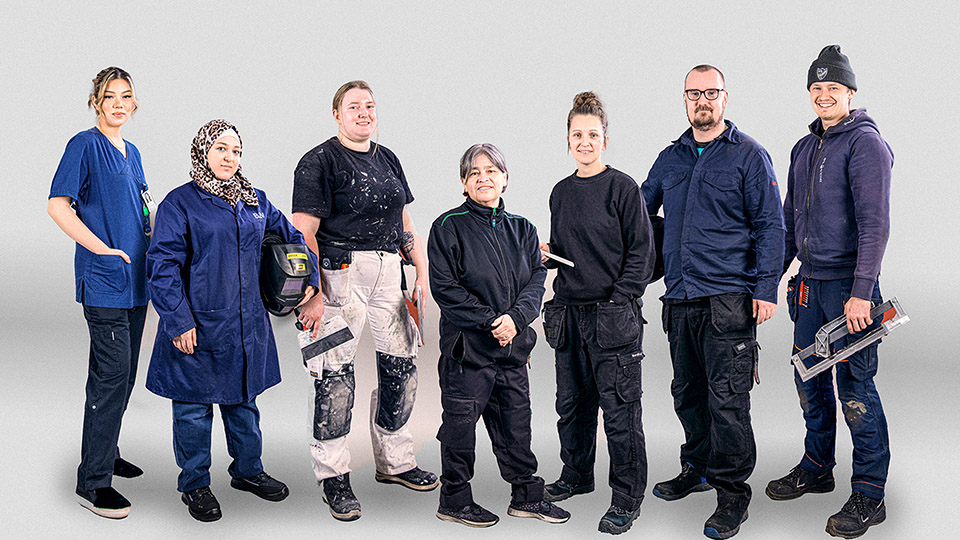Unga träarbetare under utbildning. Utomhus. Soligt väder.